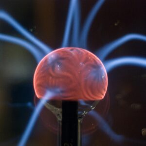 Close-up view of a plasma ball exhibiting mesmerizing electric arcs in a dark setting.